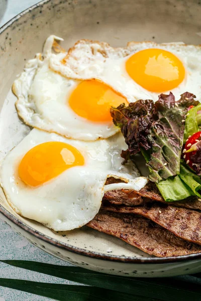 Изысканные яичницы с ростбифом и салатом — стоковое фото
