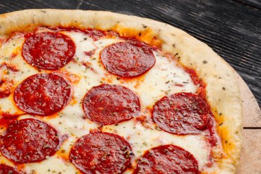 Ahşap arka planda taze fırında peponi pizza.