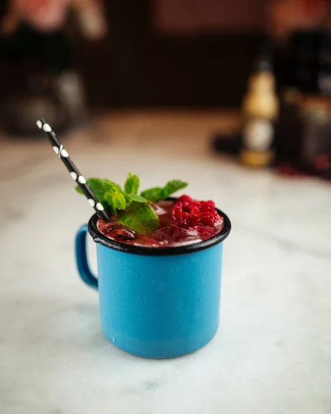 Tasse bleue de cocktail aux baies alcoolisées avec paille — Photo