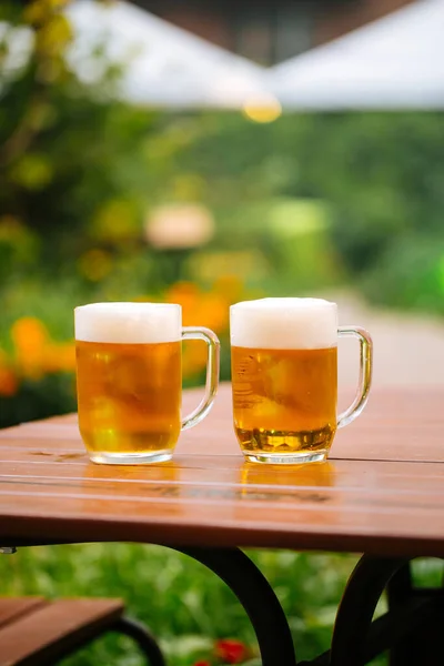 Glass mugs of beer on the table in a cafe terrace — Stock Photo, Image