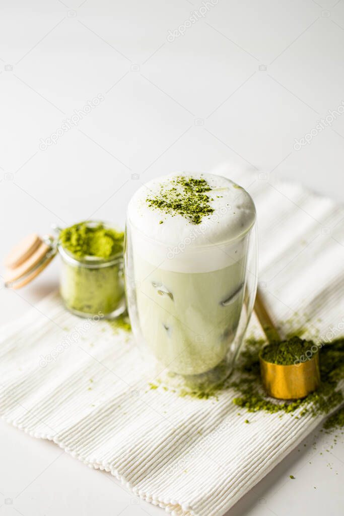 Glass of matcha green tea with ice cubes