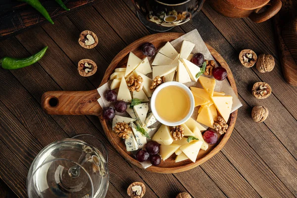 Cheese appetizer platter with grapes and honey — Stock Photo, Image