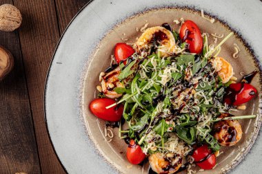 Domates ve parmesanlı karides ve roka salatası.