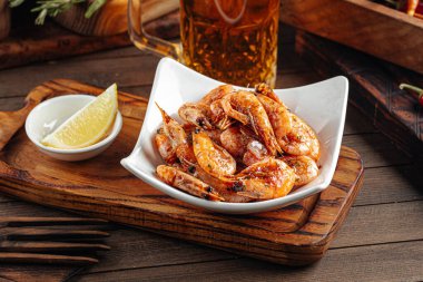 Kızarmış sarımsaklı karides aperatifi ve bira.