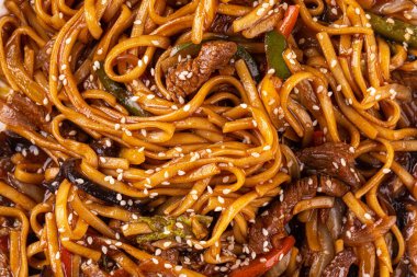 Udon noodles with vegetables and meat closeup