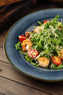 Domates ve parmesanlı karides ve roka salatası.