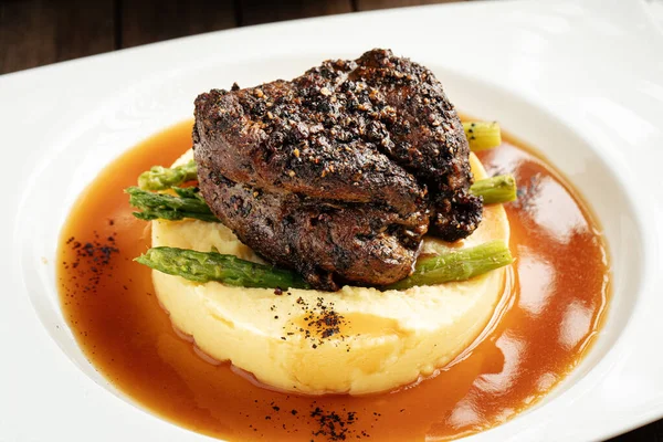 Pepper steak with mashed potatoes and asparagus