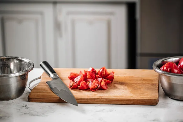 Chopped tomatoes on a kitchen desk with a knife — Stock Photo, Image