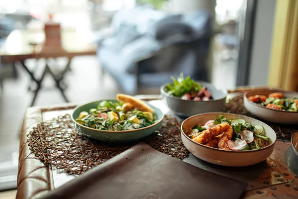 Стол с различными блюдами из салата для гурманов — стоковое фото