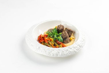 Geleneksel Türk kofta köfteleri ızgara sebze ve humus ile servis edilir beyaz arka plan üzerinde zarif beyaz tabak