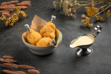 Koyu dokulu soslu seramik kasede servis edilen kızarmış tavuk budu.