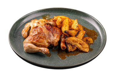 İzole edilmiş yarım tavuk. Koyu bir tabakta altın patatesle servis ediliyor.