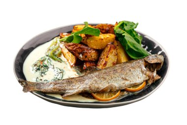 Fırınlanmış alabalık, kızarmış patates dilimleri, taze yeşiller ve kremalı bitki sosuyla servis edilir.