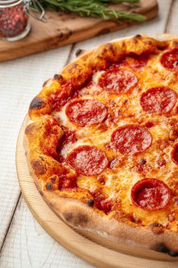 Domates soslu acı biberli pizza ve ahşap bir tahtanın üzerinde eritilmiş peynir.