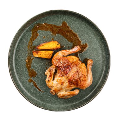 İzole edilmiş yarım tavuk. Koyu bir tabakta altın patatesle servis ediliyor.