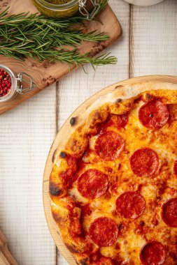 Domates soslu acı biberli pizza ve ahşap bir tahtanın üzerinde eritilmiş peynir.