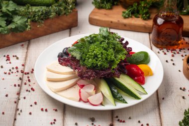 Renkli taze sebzeler içinde salatalık, biber ve peynir dilimleri tabakta.