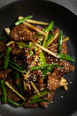 Taze soğan, susam tohumu ve aromatik sosla karıştırılmış tuzlu biftek.