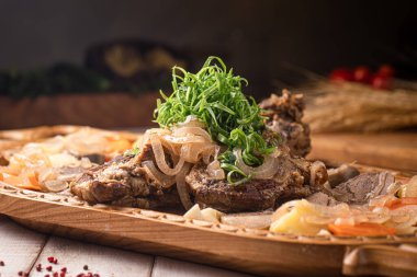 Geleneksel Kazak beshbarmak et sebzeleri ve otlarla oyulmuş şenlikli bir tabak hazırladı.