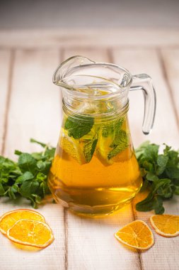 Soğuk, ferahlatıcı narenciye içeceği taze nane yapraklarıyla buz küpleri ve sürahide servis edilen tatlı aromayla.