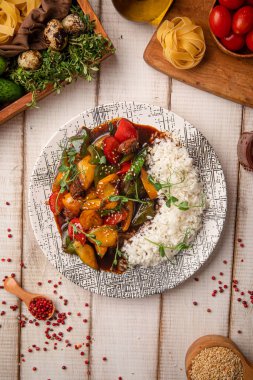 Tayland usulü kızarmış et, sebze, buğulanmış pirinç ve sade bir restoran tabağında otlarla servis edilir.