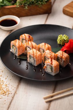 Philadelphia suşisi krem peynirli, salatalıklı ve kurutulmuş somonlu wasabi ile servis ediliyor.