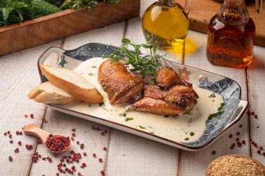 Geleneksel Gürcü chkmeruli tavuğu kızartılmış ve kremalı sarımsak sosuyla servis edilmiş kırsal bir tabakta ekmek.