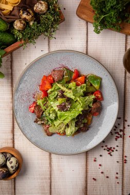 Taze et salatası, yeşil yapraklı, kiraz domatesli ve sade bir masada seramik tabakta servis edilen hafif soslu.