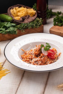 Baharatlı domates, rendelenmiş peynirli, taze otlu ve turplu. Kırsal masada servis edilen beyaz tabakta.