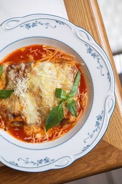 Makarna katmanlı klasik lazanya zengin domates sosu erimiş peynir ve taze fesleğen.