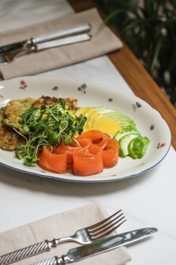 Avokado dilimli sağlıklı kahvaltı tabağı somon yumurtası sosu mikroçerez ve sebzeli börek.