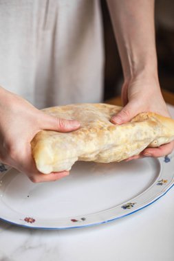 Geleneksel Gürcistan peynirli yassı ekmek ve eritilmiş sulguni restoranın içinde servis edilir, doğal ışıkta yumuşak gölgelerle fotoğraflanır.