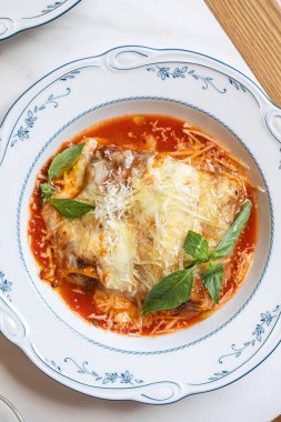 Makarna katmanlı klasik lazanya zengin domates sosu erimiş peynir ve taze fesleğen.