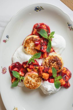 Geleneksel şuruplu krepler taze nane ve ekşi kremayla servis edilir.