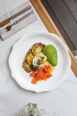 Çıtır kabaklı börek, füme somon, avokado ve ekşi kremayla servis ediliyor.