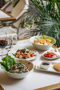 Taze salatalı İtalyan restoranı masası peynirli makarna sosu ve kırmızı beyaz şarap.