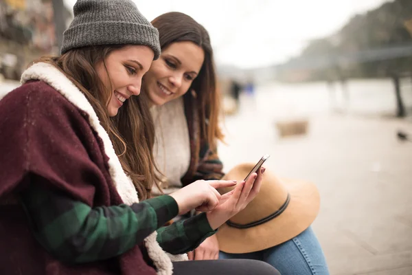 Friends with a smartphone in street — Stock Photo, Image