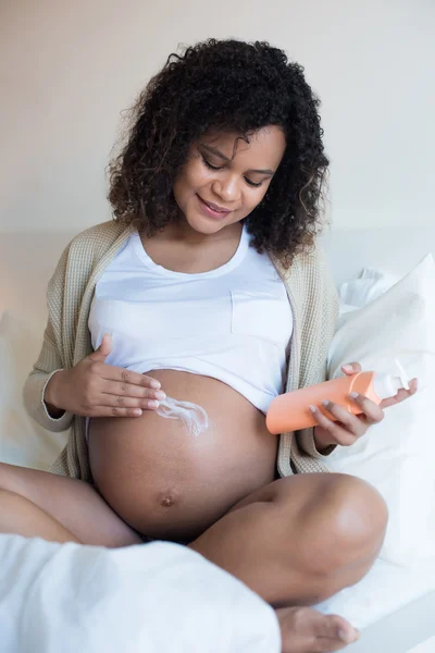 Gravid kvinna fuktgivande mage — Stockfoto
