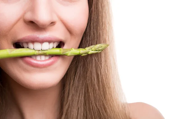 Girl biting asparagus — Stock Photo, Image