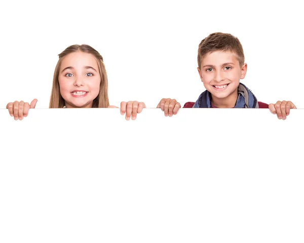 Crianças atrás de uma tábua branca — Fotografia de Stock