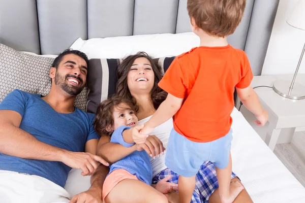 Familie op bed — Stockfoto