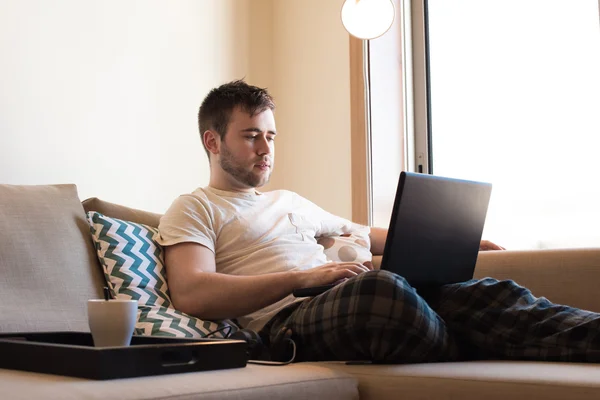 Homem com laptop na sala de estar — Fotografia de Stock