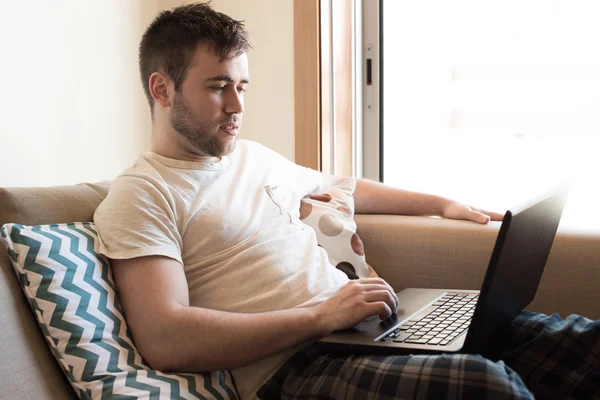 居間でノート パソコンを持つ男 — ストック写真
