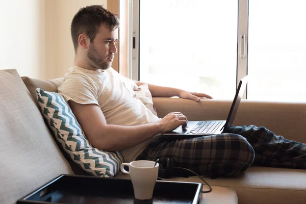 Homem com laptop na sala de estar — Fotografia de Stock