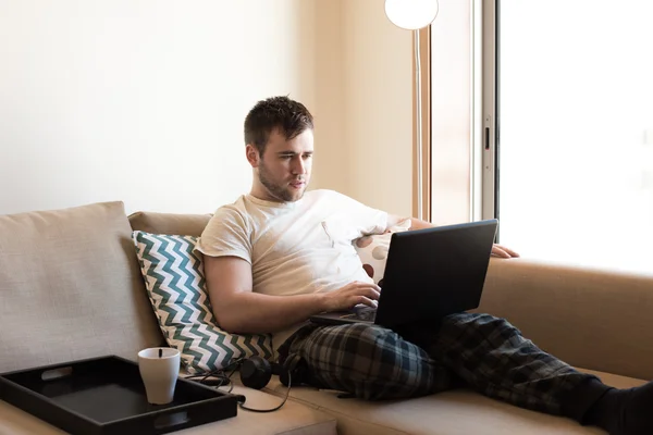 居間でノート パソコンを持つ男 — ストック写真