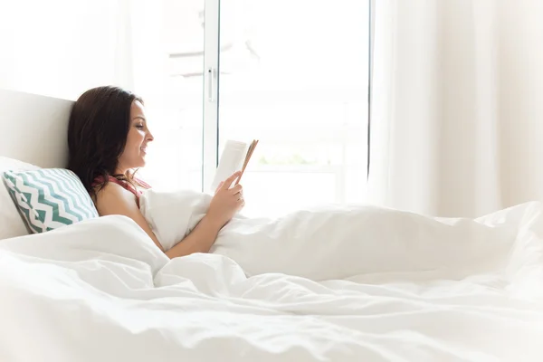 Frau liest im Bett — Stockfoto