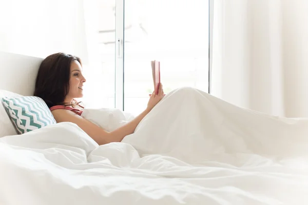 Lezende vrouw in bed — Stockfoto