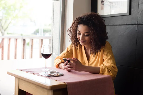 Femme avec smartphone au restaurant — Photo