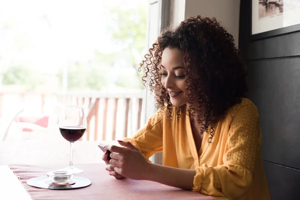 Vrouw met smartphone in restaurant — Stockfoto