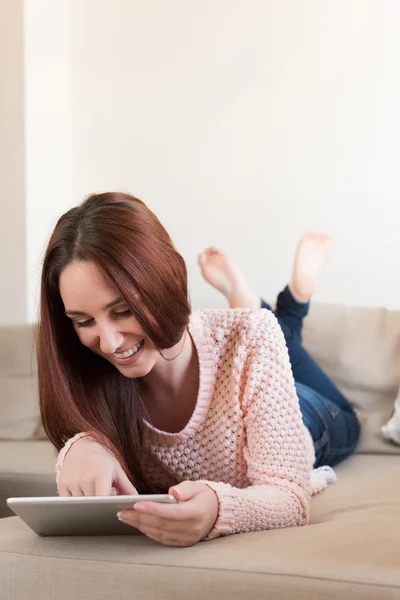 Mulher no sofá com tablet — Fotografia de Stock